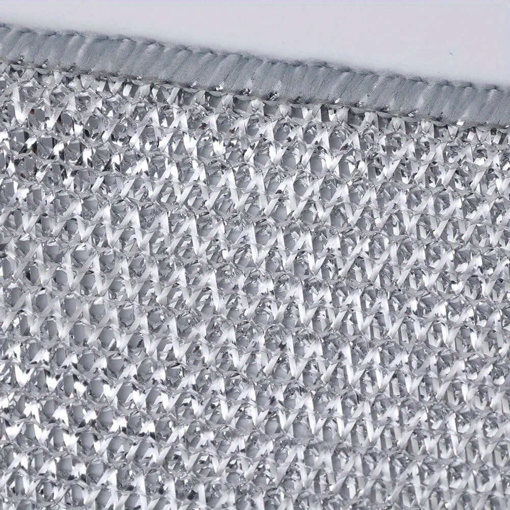 Close-up of textured non-stick oil cloth fabric, ideal for dishwashing, featuring a contemporary knit design.