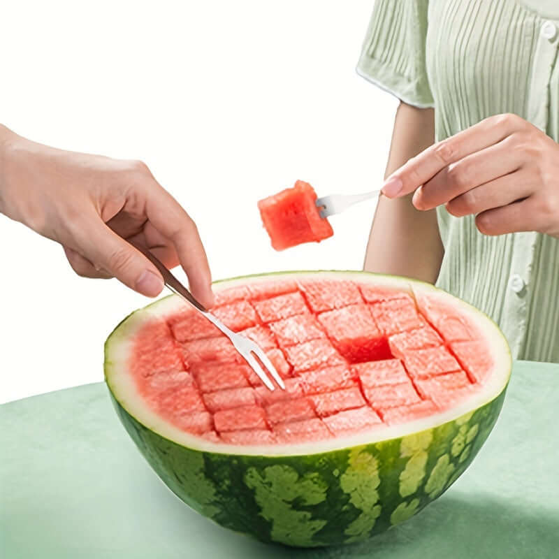 Two hands using forks to enjoy perfectly cubed watermelon slices from a beautifully cut watermelon.