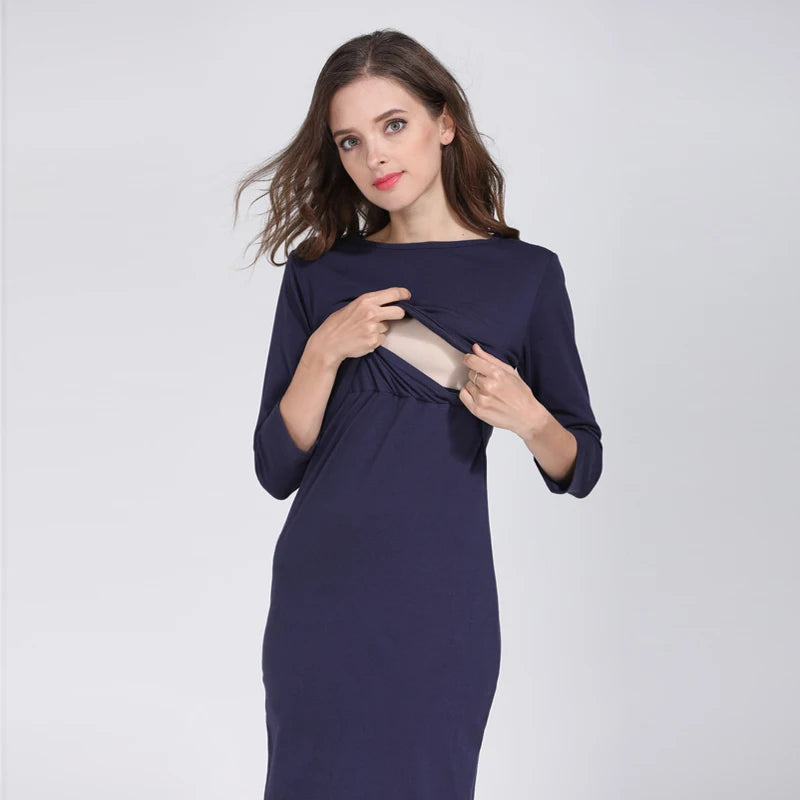 Model wearing a navy postpartum nursing maternity dress with 3/4 sleeves, designed for breastfeeding convenience.