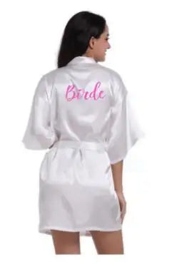Back view of a woman wearing a satin robe with the word 'Bride' in pink, ideal for wedding celebrations.