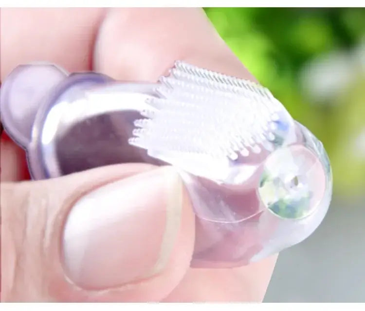 Close-up of a silicone baby toothbrush designed for gentle training, held in hand, ideal for infants and toddlers.