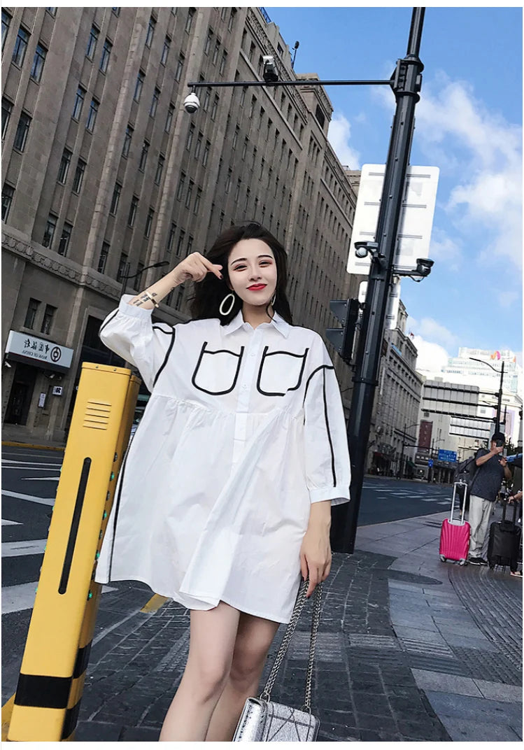 Woman wearing a stylish solid color shirt dress with pockets, posing on an urban street.