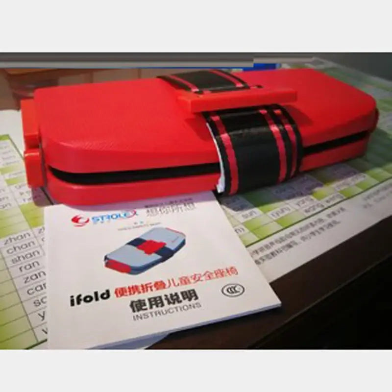 Minifold Portable Baby Car Seat Safety in red, compact design with instructions manual beside it, ideal for ages 1-6.