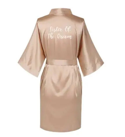 Rose gold satin bridesmaid robe with 'Sister of The Groom' text, short sleeves, and waist tie, perfect for wedding parties.