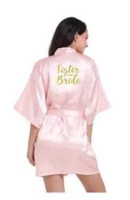 Light pink satin bridesmaid robe with 'Sister of the Bride' text on back, perfect for weddings and bridal parties.