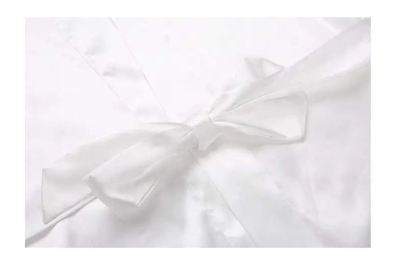 Close-up of a white satin bridesmaid robe with a delicate bow, perfect for elegant weddings.