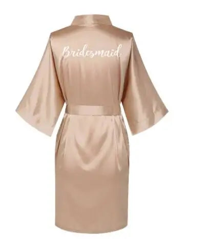 Rose gold satin bridesmaid robe with embroidered "Bridesmaid" lettering on the back.