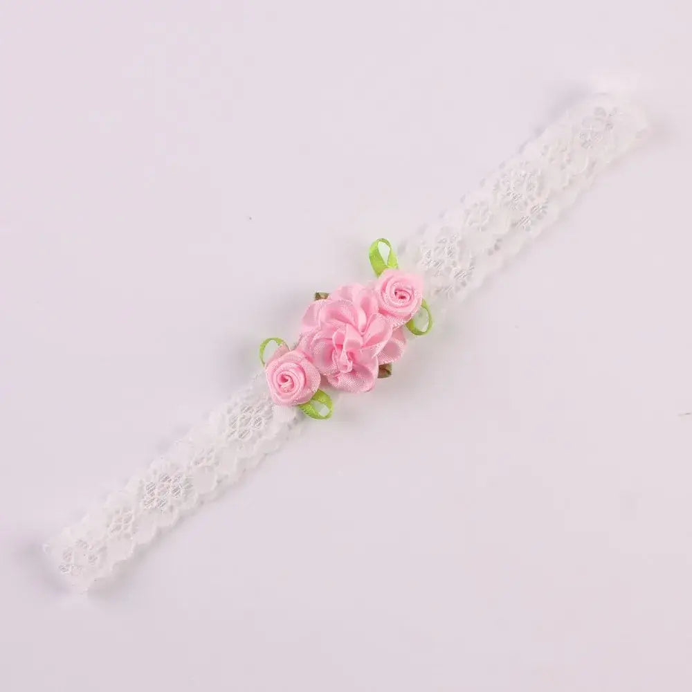 Delicate white lace headband with pink rose flowers and green ribbons for baby girls.