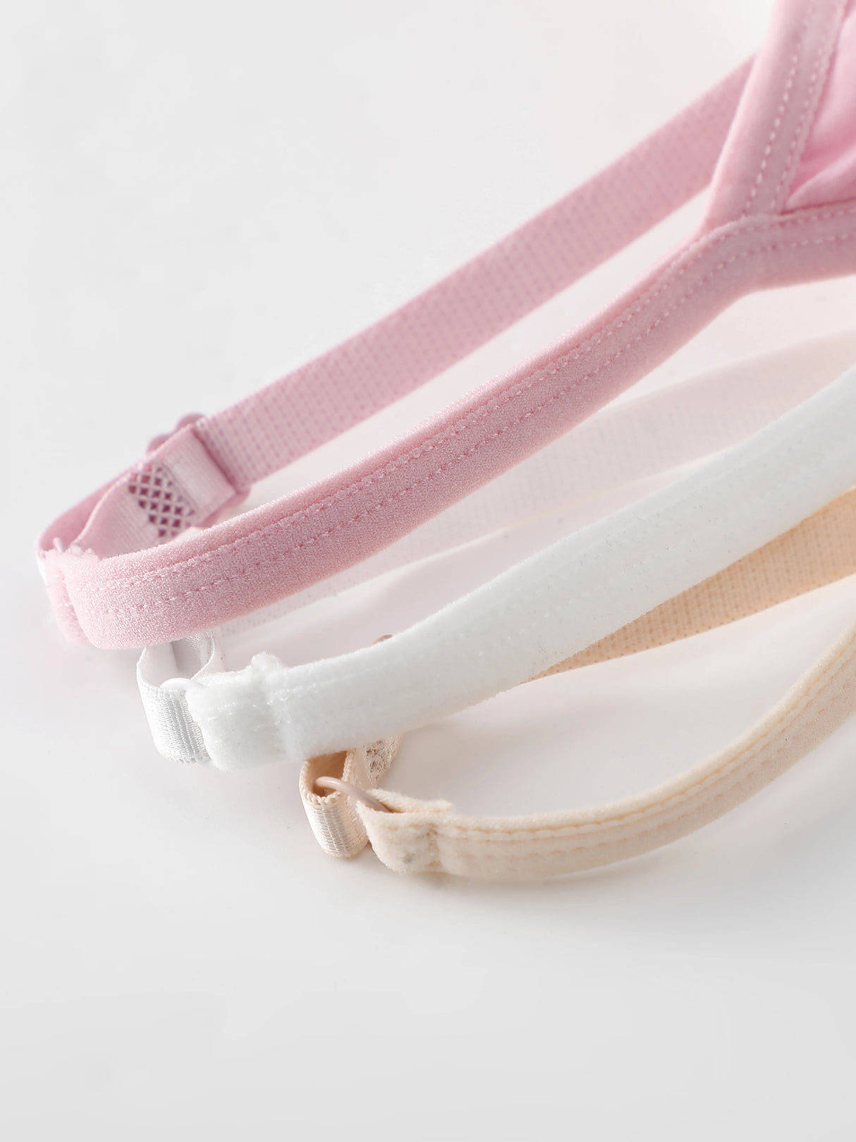 Adjustable bra straps in pink, white, and beige colors, demonstrating comfort and versatility.