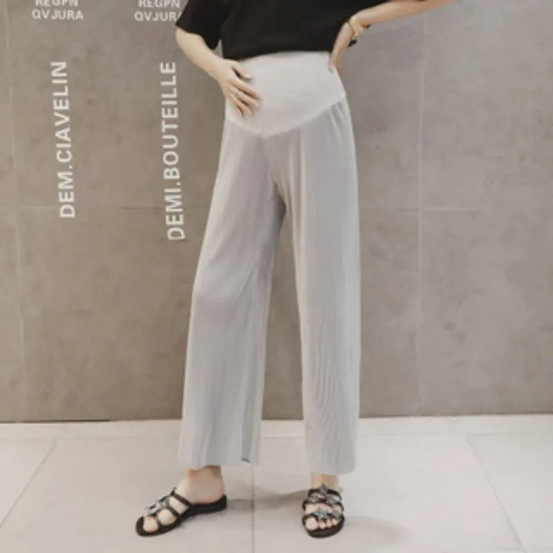 Light gray pleated maternity pants on a model, perfect for summer, featuring a loose fit and comfortable waistband.