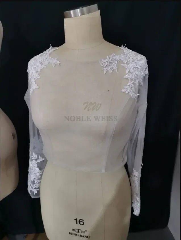 Lace bridal bolero with long sleeves and floral appliqué, perfect for elegant wedding attire.