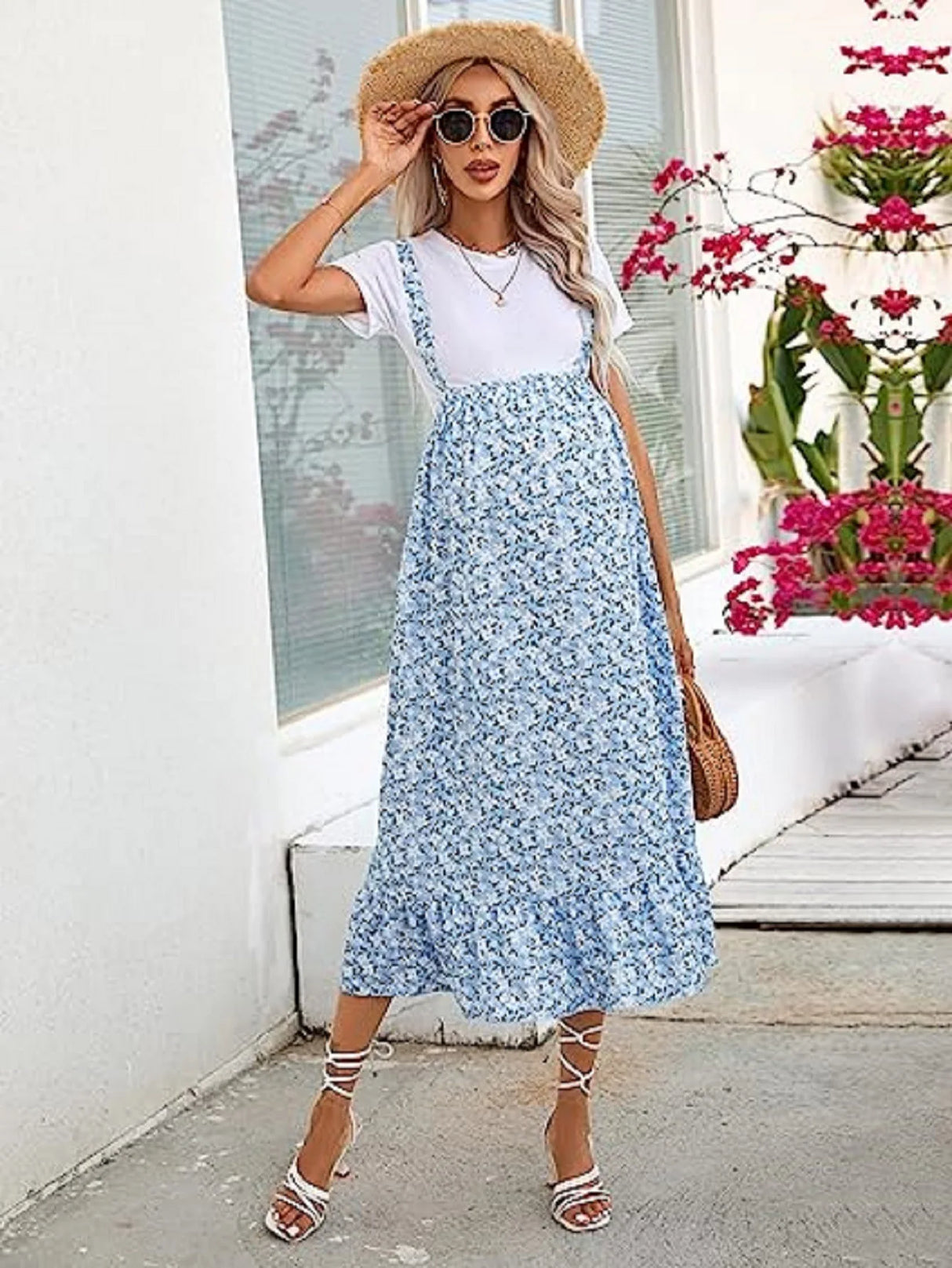 Woman wearing a comfortable blue floral spring summer dress with a white t-shirt and straw hat.