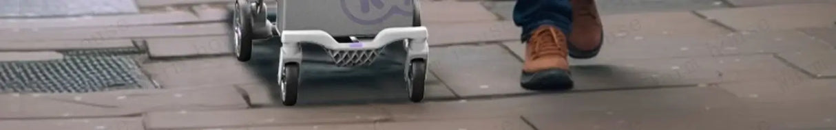 Outdoor lightweight children's stroller being pushed on a sidewalk beside a person in brown shoes.