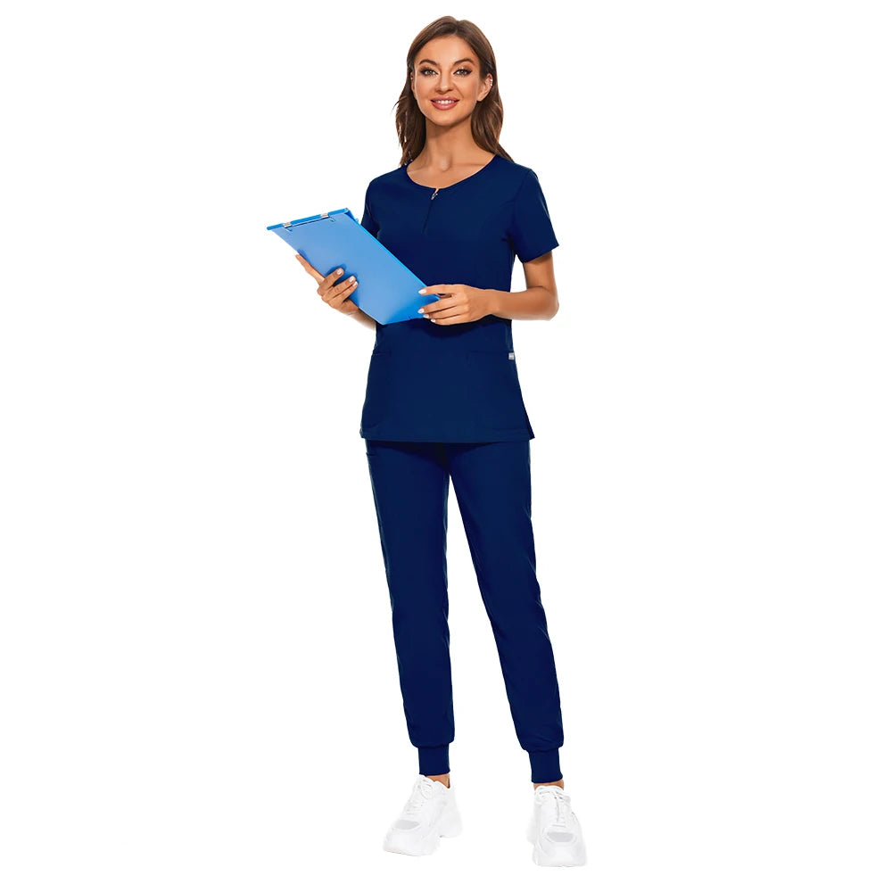 Model wearing a navy 7-color nursing work uniform with zip V-neck top and pants, holding a clipboard.