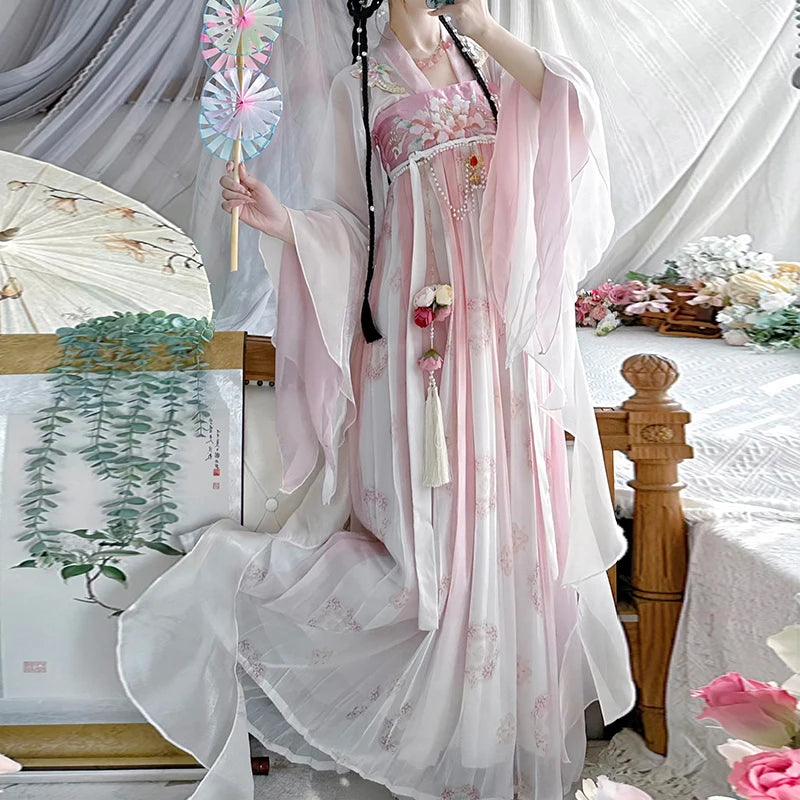Vintage Chinese style Hanfu dress in soft pink, featuring floral embroidery, worn by a woman holding a fan.