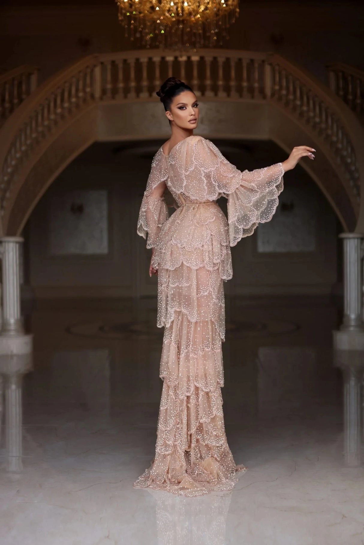 Elegant Arabic nude stone wedding gown with tiered sleeves, beading, and a sweetheart neckline in a luxurious setting.
