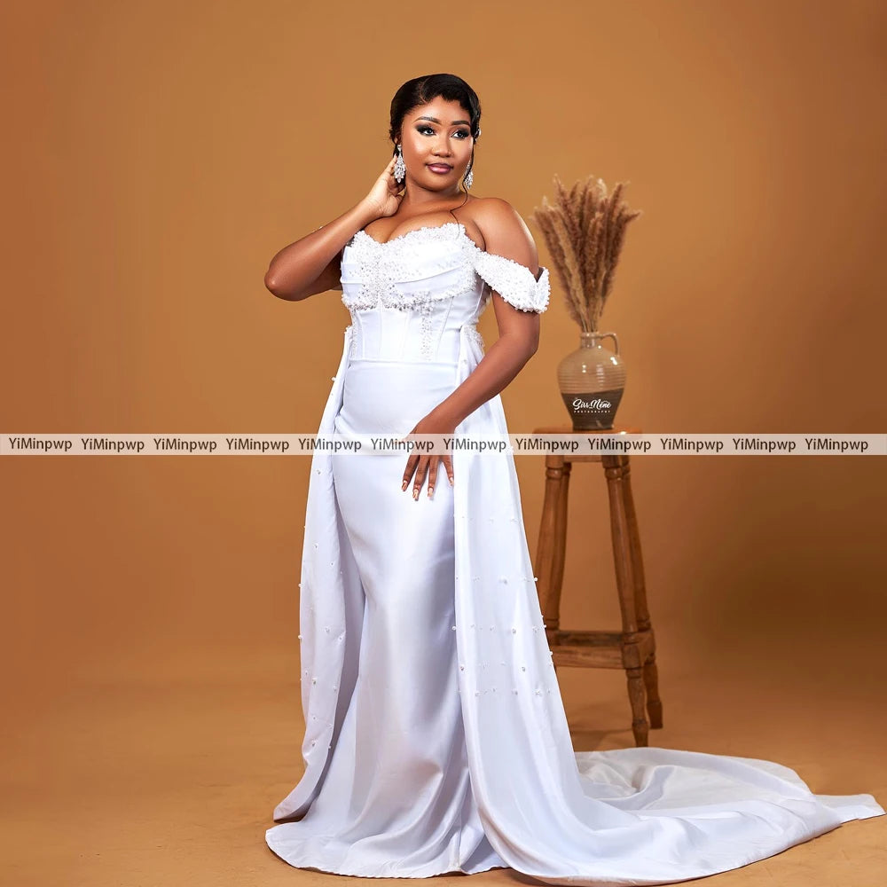 Elegant off-shoulder wedding dress with detachable train and pearl decoration, perfect for mermaid style.