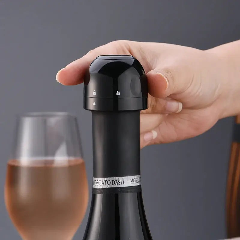 Vacuum red wine bottle cap stopper in hand, showcasing silicone seal design, ideal for preserving wine freshness.