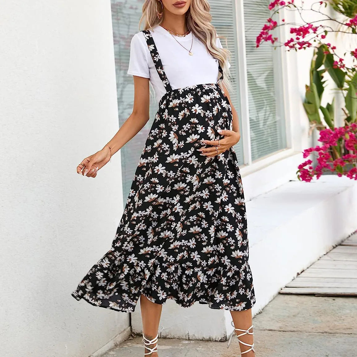 Stylish pregnant woman in comfortable floral maternity dress for spring and summer, featuring a mid-calf length and casual style.