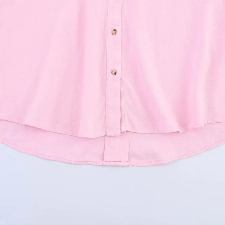 Light pink asymmetrical linen shirt with wide sleeves and button-down front.