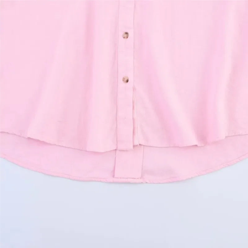 Close-up of a pink AsymLinen™ linen shirt featuring a button front and curved hemline.