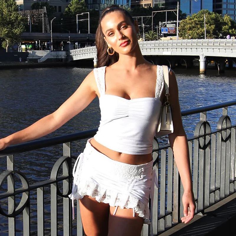 Model wearing Lace Strap Pleated Camisole Tank Top with a stylish white skirt by the river in summer.