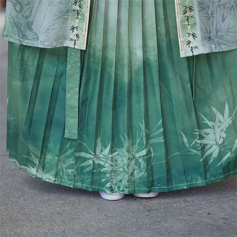 Close-up of a pleated green Women's Hanfu cosplay dress with bamboo designs, showcasing fine craftsmanship and fabric details.