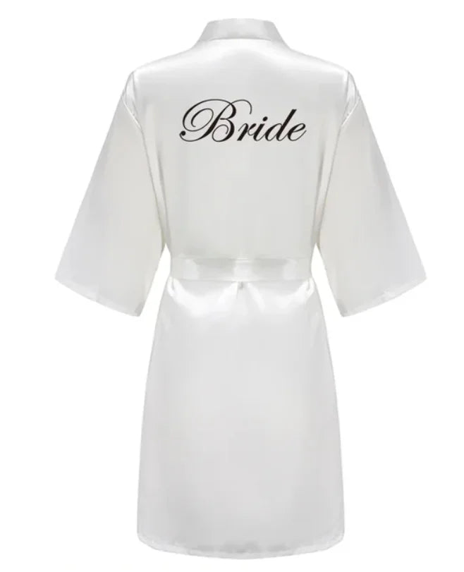 Elegant white satin robe with 'Bride' written in cursive, perfect for bridal occasions and wedding preparations.