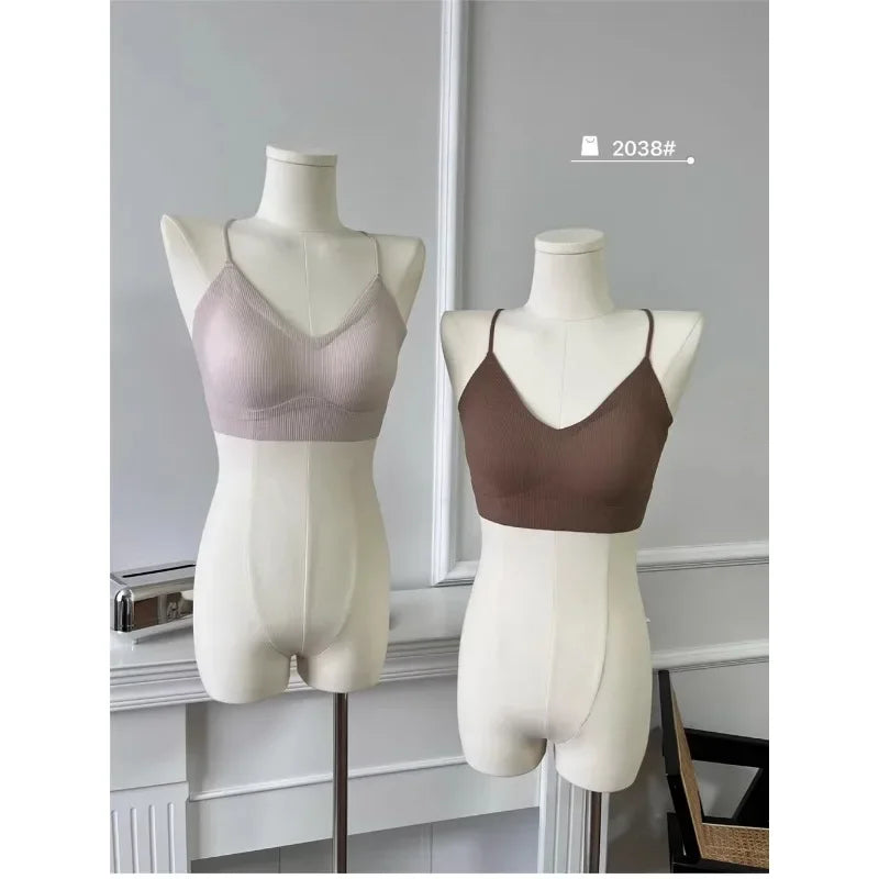 Two padded backless tank tops on mannequins, one in light pink and one in brown, showcasing summer fashion.
