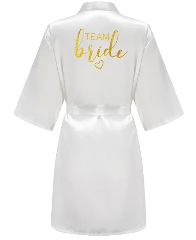 White satin robe with 'TEAM BRIDE' in glittery gold lettering on the back, perfect for bridal parties.
