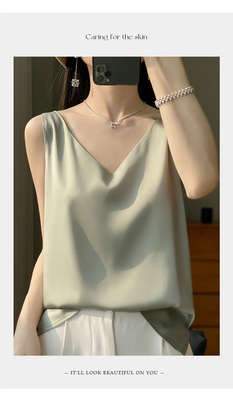 Woman modeling a V-neck sleeveless satin camisole top in soft green, showcasing a stylish summer outfit.