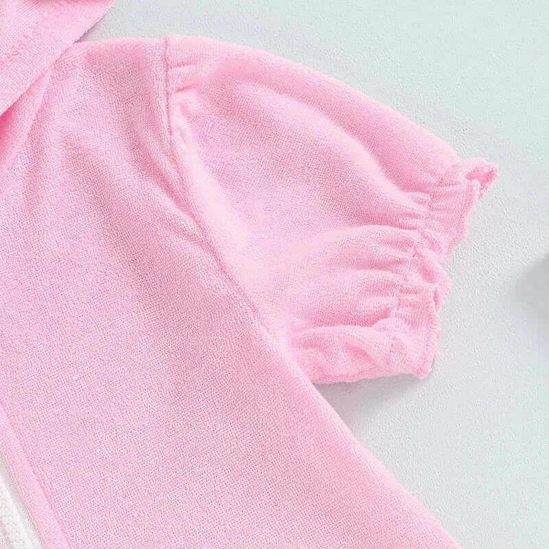 Close-up of toddler girls short sleeve pink hooded dress with ruched sleeve details.