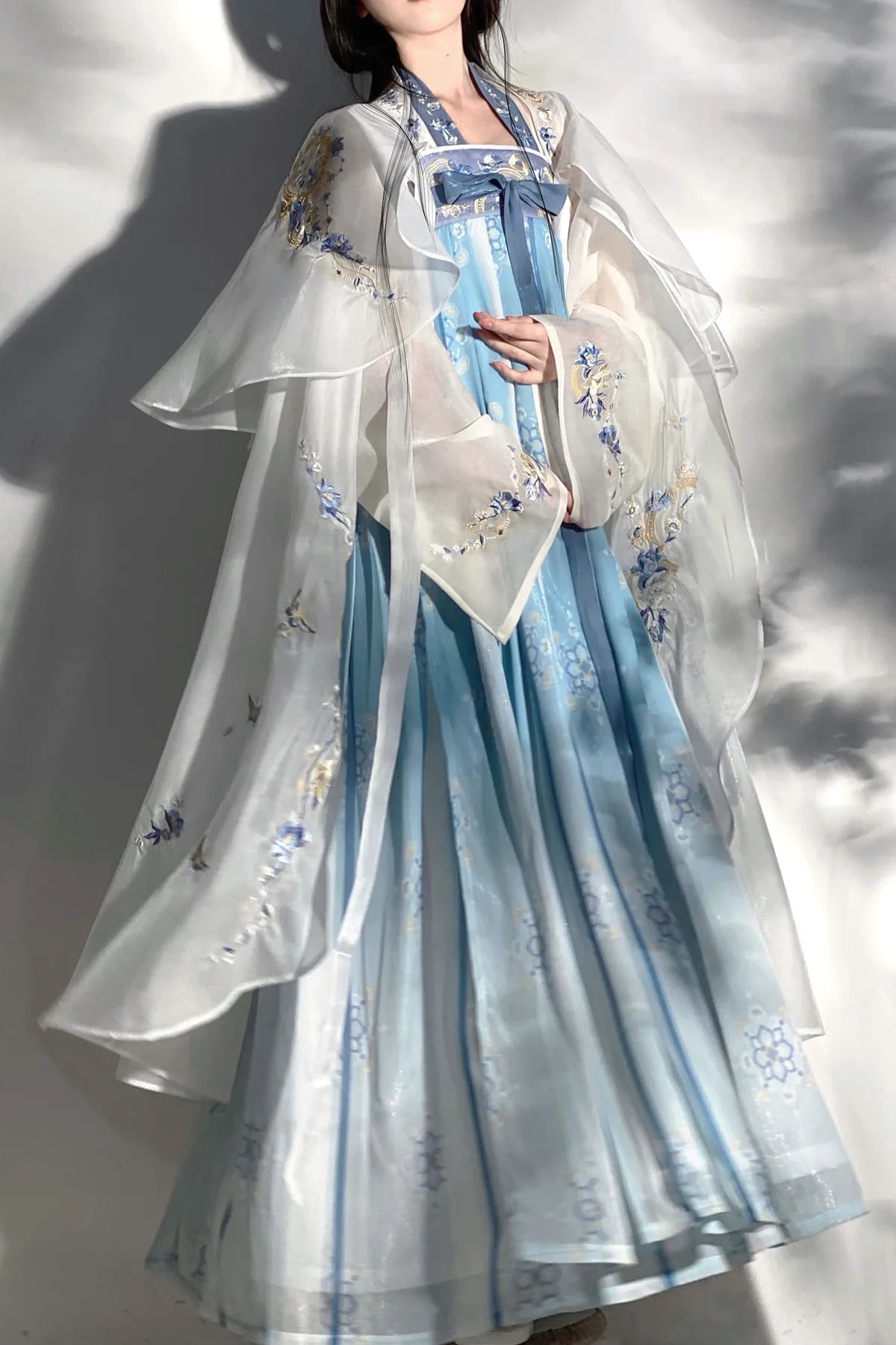 Elegant women's summer fairy hanfu costume in soft blue, featuring delicate floral patterns and a flowing design.