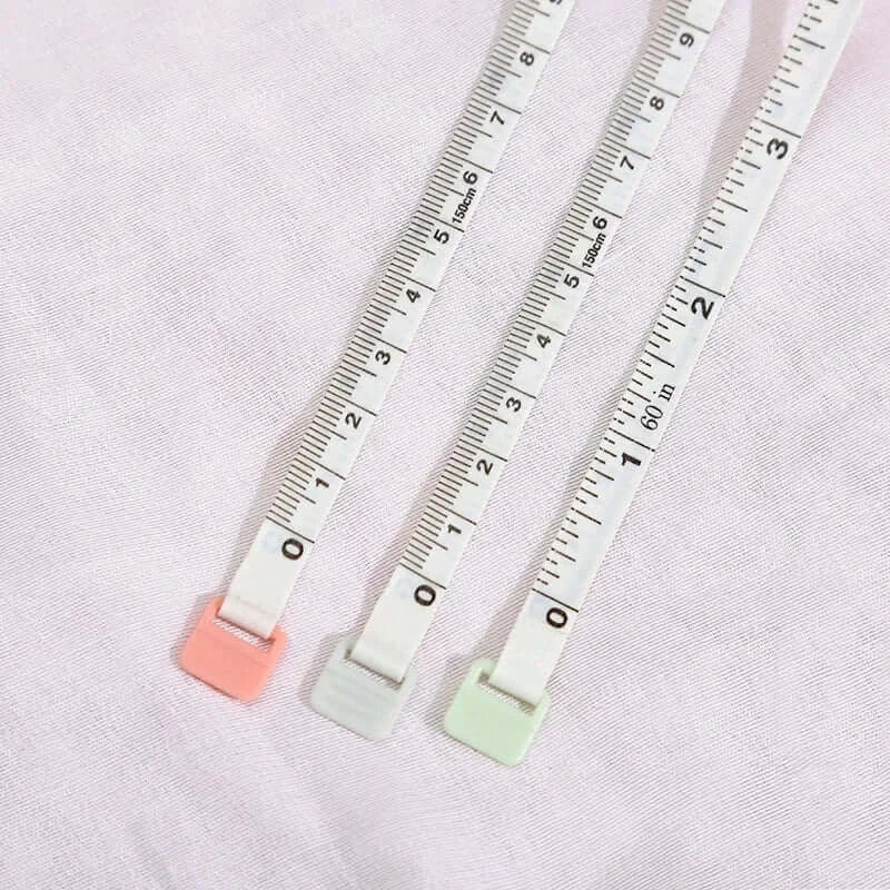 Set of three colorful mini baby height rulers in soft plastic, measuring up to 150cm on a white fabric background.