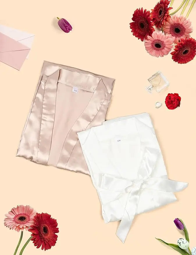 7-piece satin bride robe set in blush and white on a floral background, perfect for bridal party gifts.