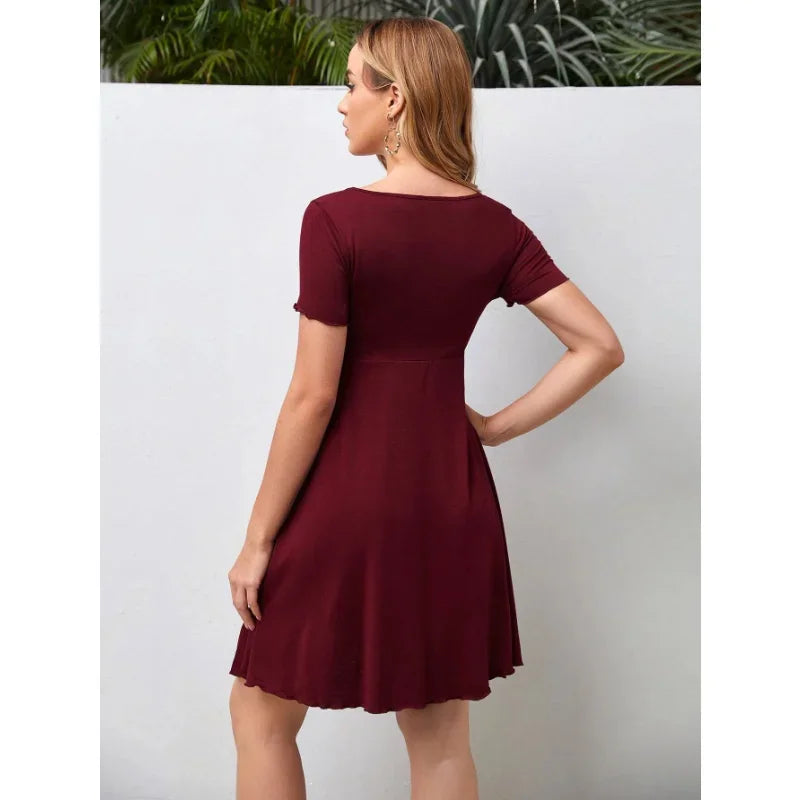Back view of a woman wearing a burgundy pure color V-neck maternity dress, featuring a knee-length A-line silhouette.