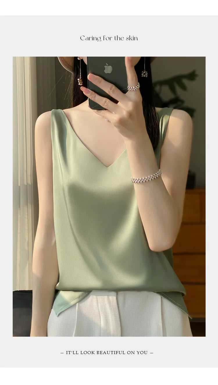 Woman wearing a green satin V-neck camisole, showcasing summer style and comfort in a casual setting.