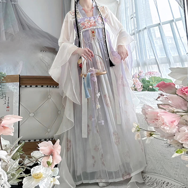 Vintage Chinese style traditional Hanfu dress with flowing sleeves, worn by a woman in a floral setting.