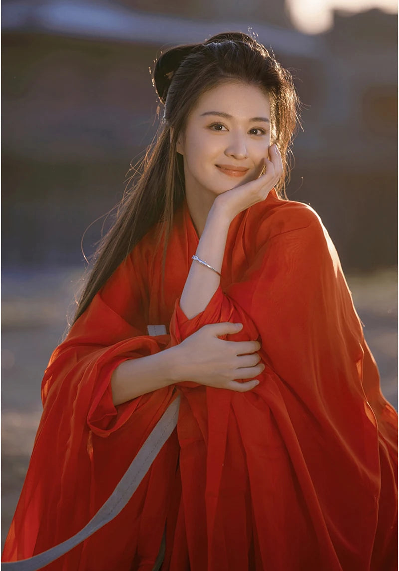 Woman in a beautiful red Hanfu dress smiling, ideal for cosplay and traditional events.