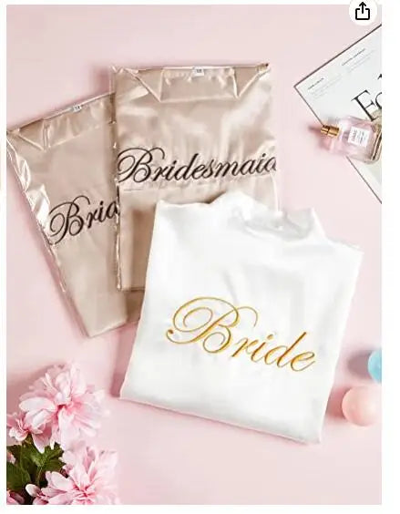 Set of bridal party robes including 'Bride' and 'Bridesmaid' designs on a pink background.
