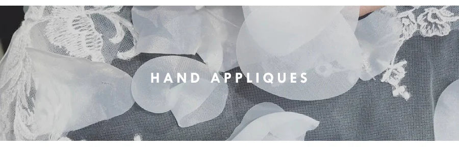 Close-up of elegant hand appliques on fabric, showcasing intricate detailing and craftsmanship.