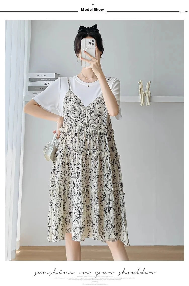 Model wearing a cute spaghetti strap layered dress with floral pattern, styled with a white t-shirt and a bow hair accessory.