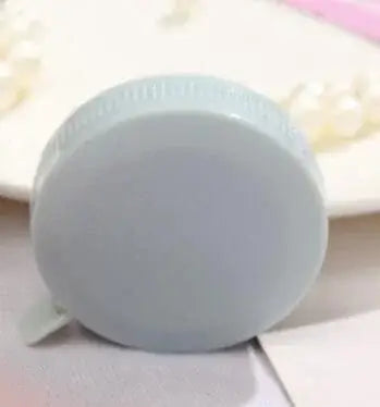 Round white tape measure for measuring heights, suitable for kids and baby height tracking, made of plastic and metal.