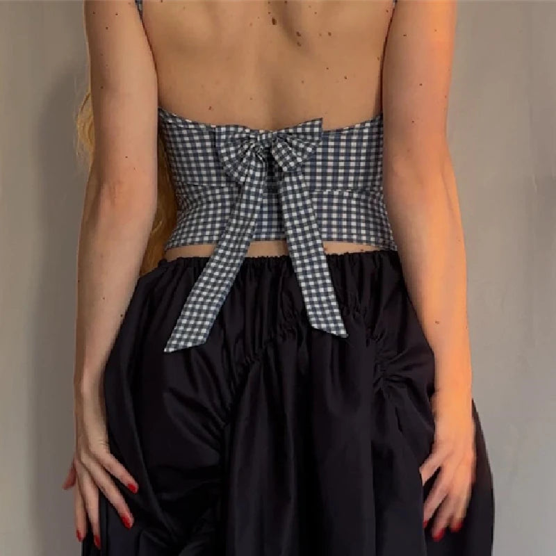 Back view of a plaid bow backless Y2K crop top, styled with a black skirt, showcasing trendy streetwear fashion.