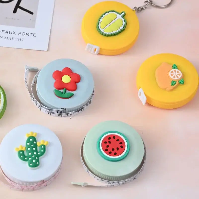 Colorful decorative tape measures featuring fruit and flower designs, perfect for adding fun to home decor and crafts.