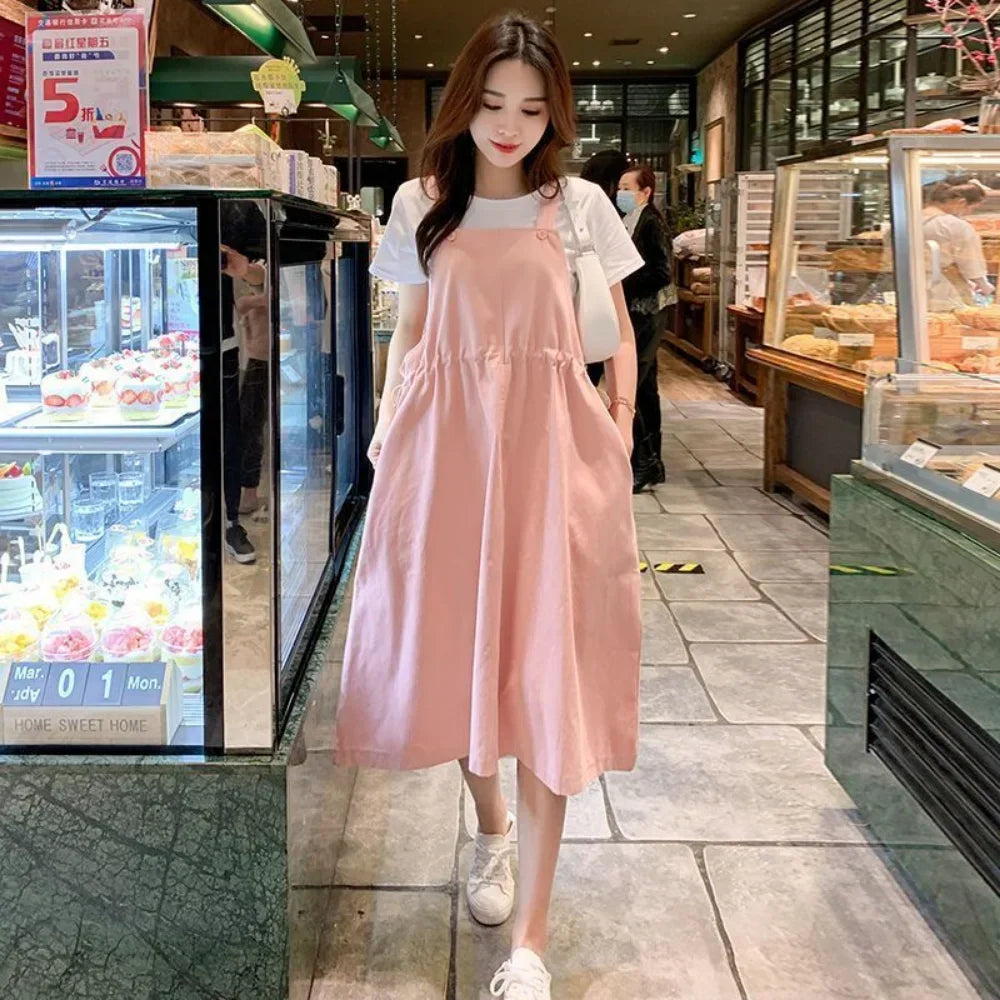 Woman in a pink loose fit maternity dress walking in a bakery, perfect for holiday photography outfits.