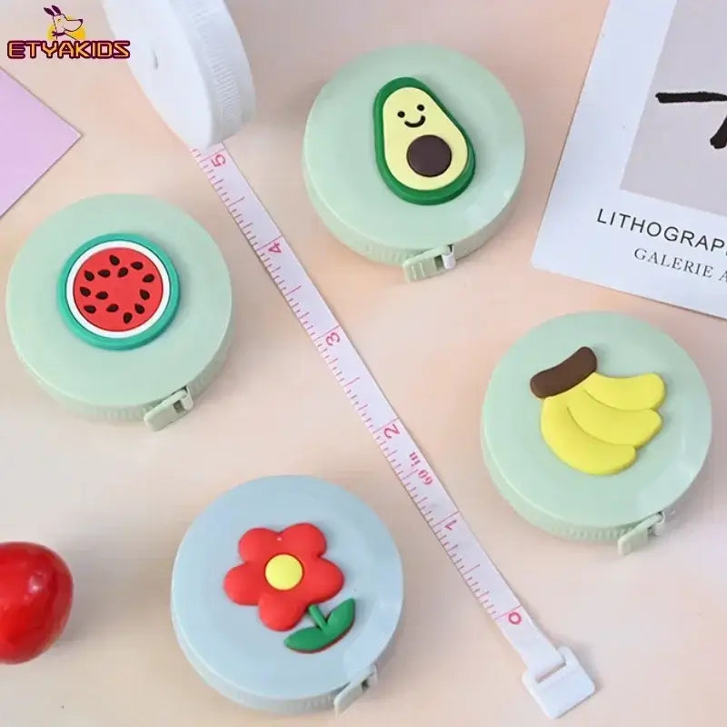 Colorful measuring tape with cute fruit designs including watermelon, avocado, bananas, and a flower, ideal for children's use.