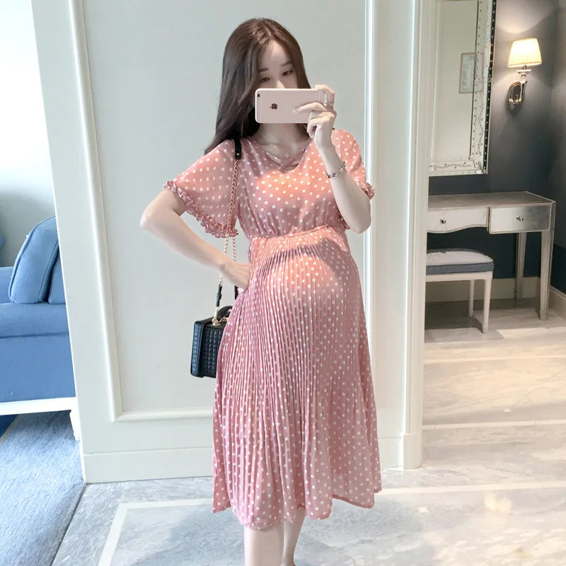 Chiffon polka dot maternity dress in pink, featuring a classic boat neck and knee-length pleated design for summer styles.