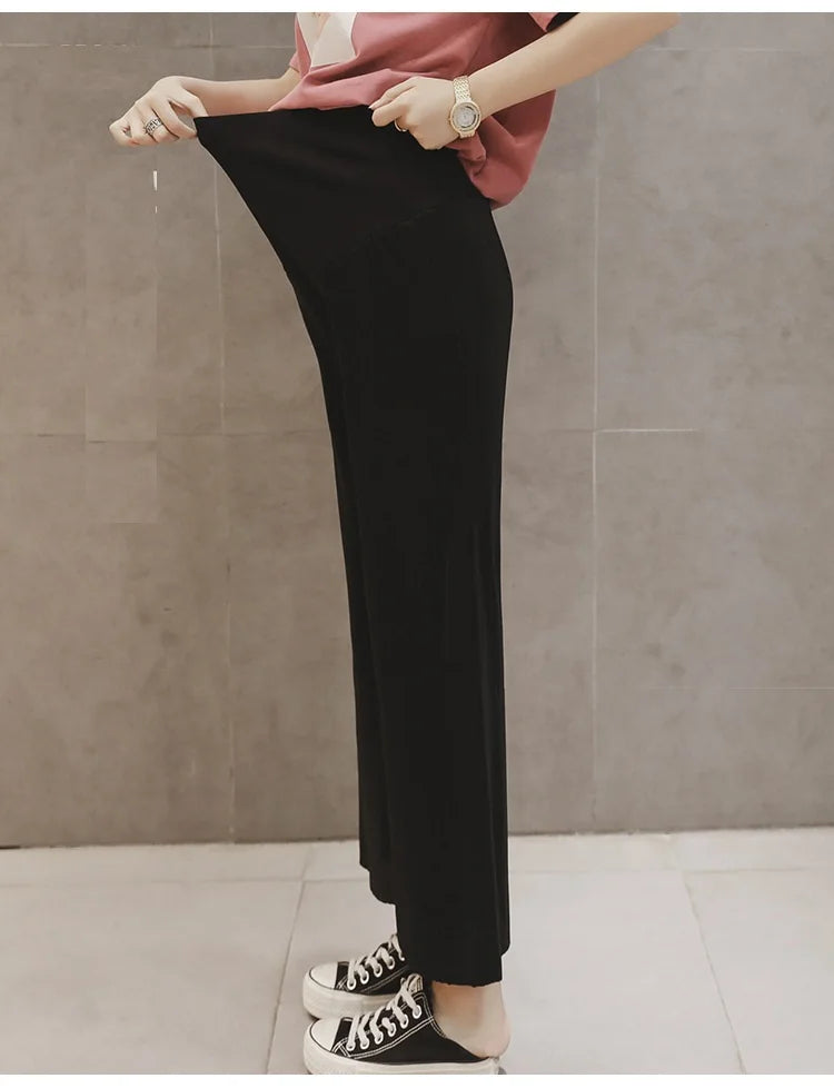 Breathable adjustable waist maternity pants in black, featuring a loose fit and pleated design, ideal for summer wear.