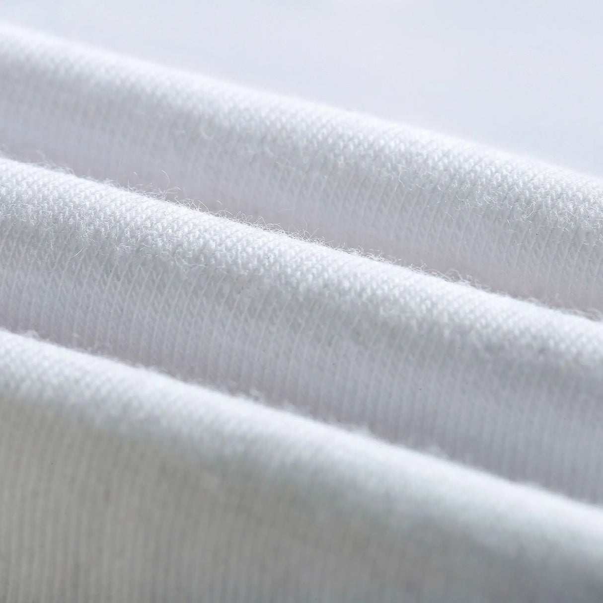Close-up of soft, white cotton fabric, showcasing its smooth texture and fine weave.